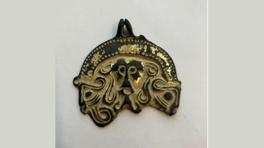 Find, A flat gilded cast copper alloy early medieval harness pendant, richly decorated with anthropomorphic and zoomorphic moulded ornament in Salin's Style I.